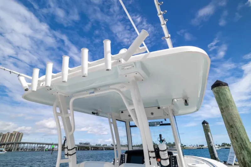 Slide: The Image of 2023 Robalo R302 Center Console boat with rod holders, under a clear blue sky. - 37