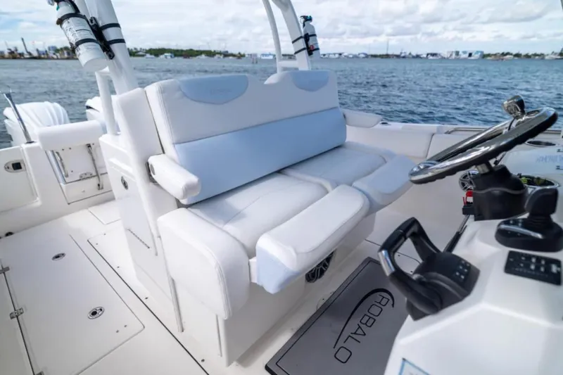 Slide: The Image of 2023 Robalo R302 Center Console boat interior with white seating and steering wheel. - 38