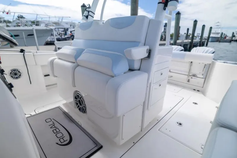 Slide: The Image of 2023 Robalo R302 Center Console boat interior with white seating and storage compartments. - 40