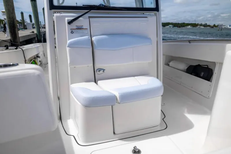 Slide: The Image of 2023 Robalo R302 Center Console boat interior with white seating and storage compartments. - 42