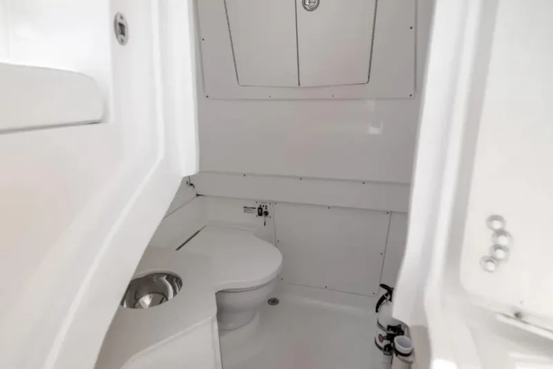 Slide: The Image of 2023 Robalo R302 Center Console boat interior with compact marine toilet. - 44