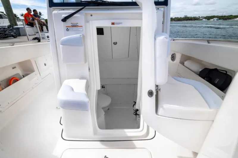 Slide: The Image of 2023 Robalo R302 Center Console boat interior with open cabin door and seating. - 45