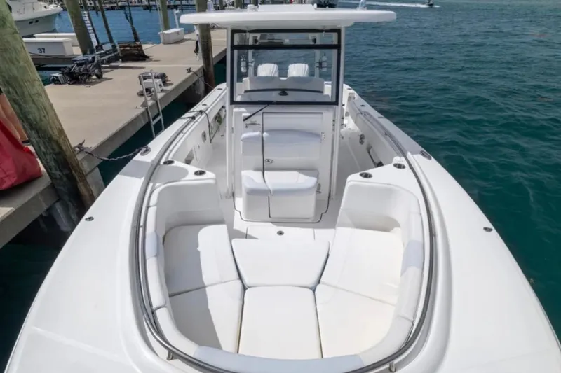 Slide: The Image of 2023 Robalo R302 Center Console boat with spacious seating, docked by the water. - 52