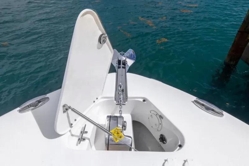Slide: The Image of 2023 Robalo R302 Center Console anchor compartment open on calm water. - 53
