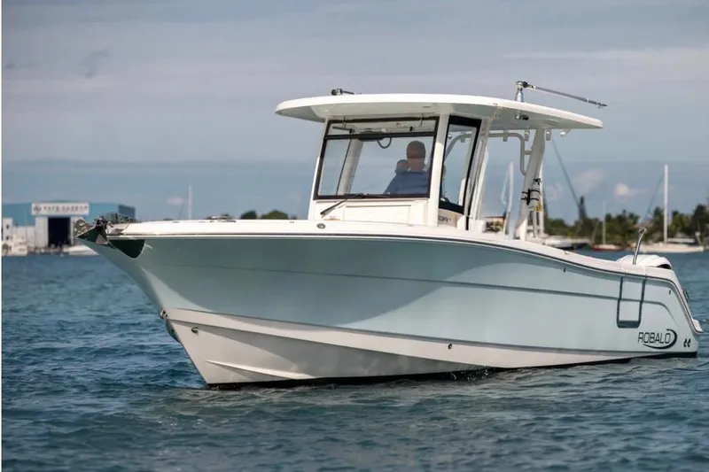 Slide: The Image of 2023 Robalo R302 Center Console boat cruising on calm blue waters. - 55