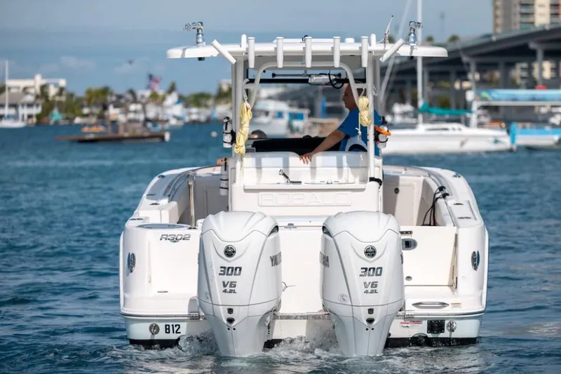 Slide: The Image of 2023 Robalo R302 Center Console boat with twin Yamaha 300 engines on water. - 7