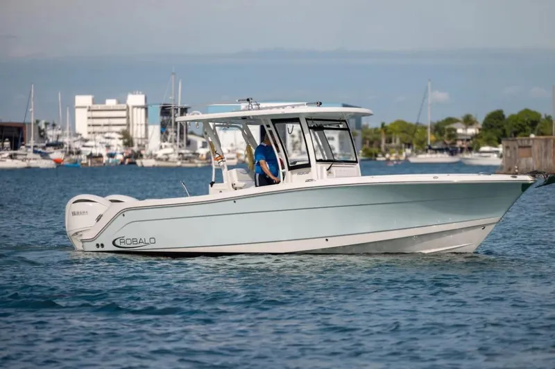 Slide: The Image of 2023 Robalo R302 Center Console boat cruising in a marina with clear skies. - 9
