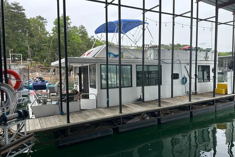 Slide: The Image of 1996 Catamaran Cruisers 12x42 houseboat docked at marina with blue canopy. - 1