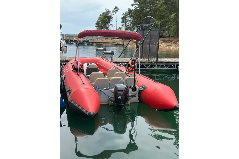 Slide: The Image of Red inflatable boat docked on calm water, featuring seating and an outboard motor. - 17