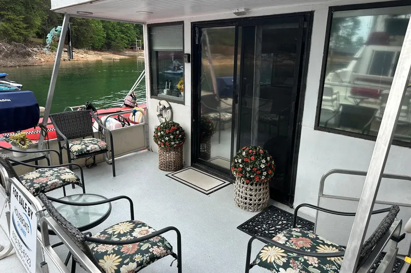 Slide: The Image of 1996 Catamaran Cruisers 12x42 houseboat with floral decor on a serene lake. - 2