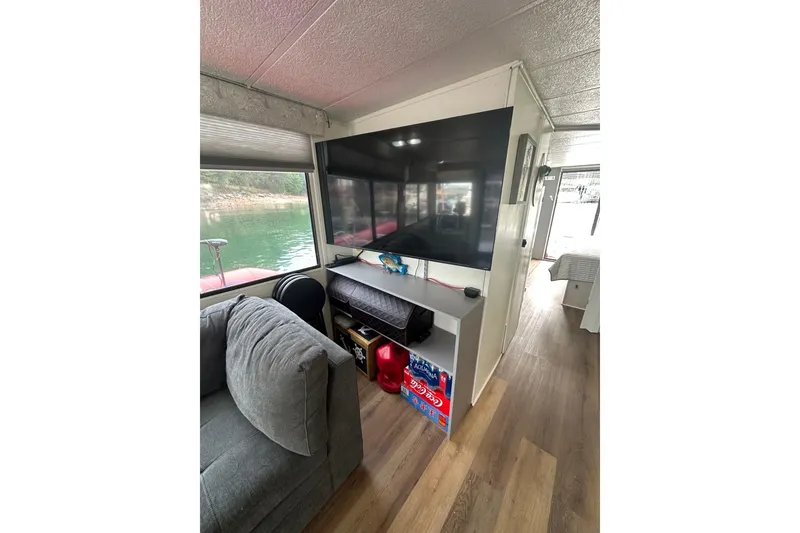 Slide: The Image of Interior of 1996 Catamaran Cruisers 12x42 with TV, sofa, and scenic water view. - 7