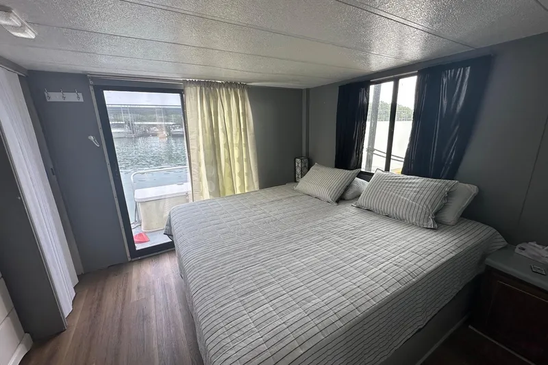 Slide: The Image of Cozy bedroom interior of a 1996 Catamaran Cruisers 12x42 houseboat with waterfront view. - 8