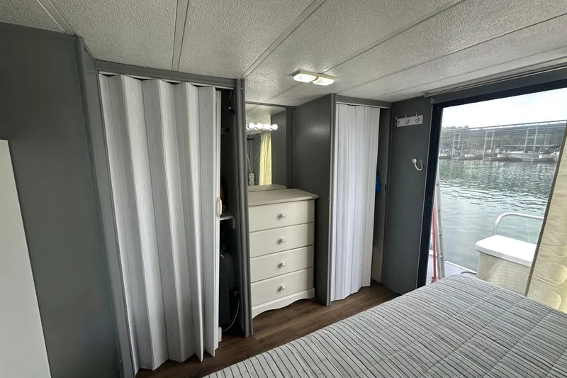 Slide: The Image of Interior of 1996 Catamaran Cruisers 12x42 with dresser, sliding doors, and water view. - 9