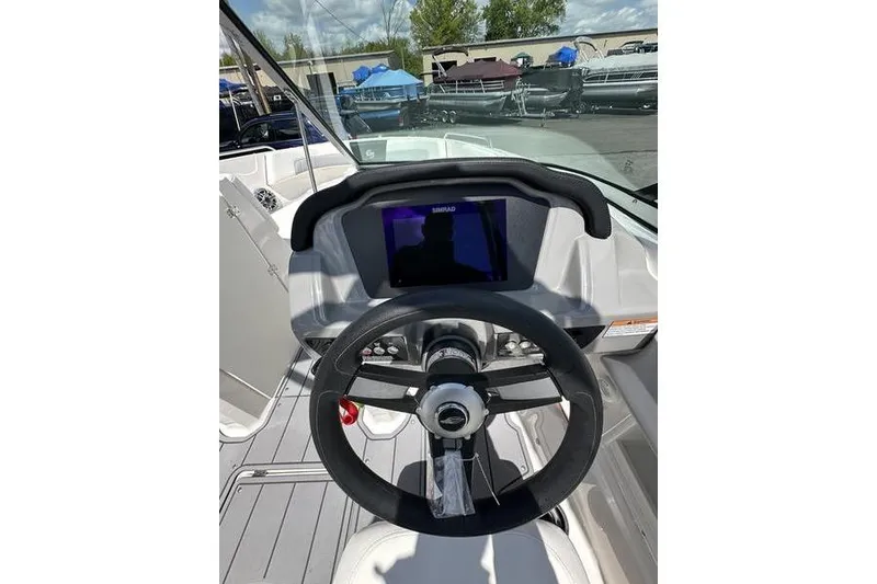 Slide: The Image of 2023 Chaparral 23 Surf boat dashboard with steering wheel and digital display. - 14