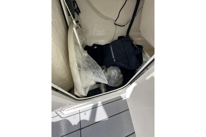 Slide: The Image of Storage compartment of 2023 Chaparral 23 Surf boat with bags and equipment. - 19