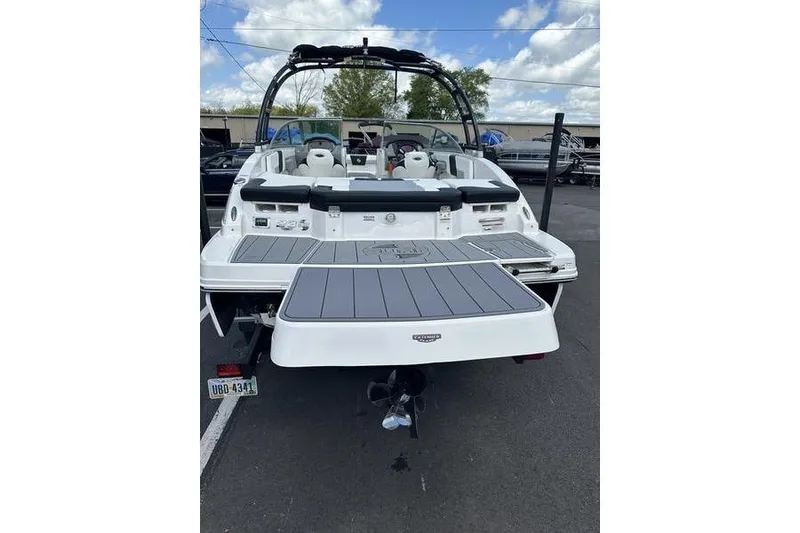 Slide: The Image of 2023 Chaparral 23 Surf boat, rear view with swim platform, parked outdoors. - 23