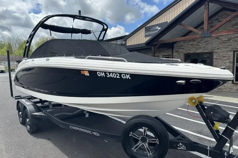 Slide: The Image of 2023 Chaparral 23 Surf boat on trailer, parked outside a building. - 25