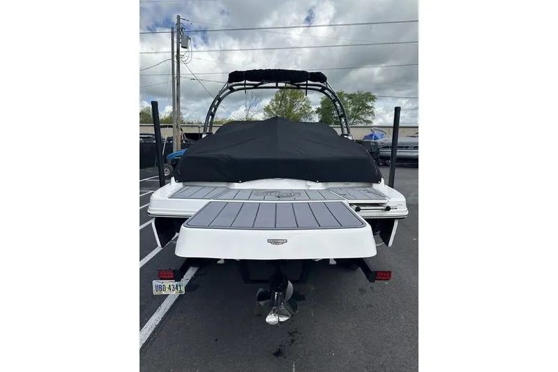 Slide: The Image of 2023 Chaparral 23 Surf boat, rear view with cover, parked outdoors. - 29