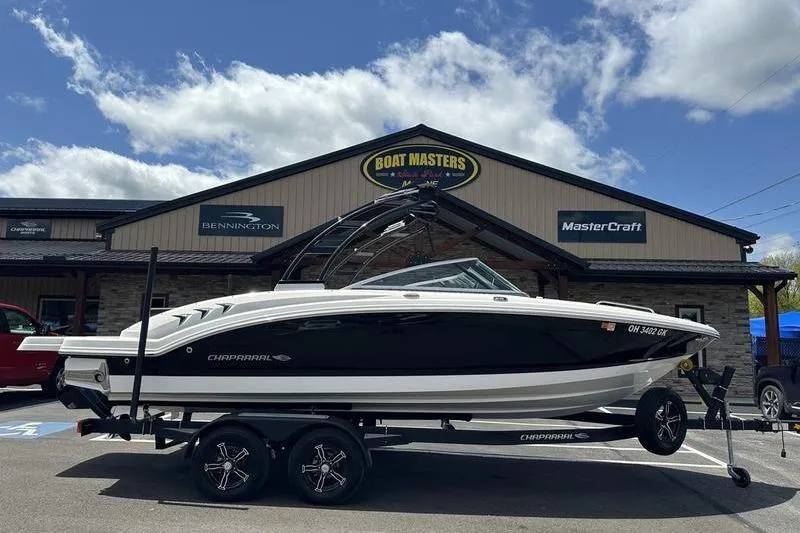 Slide: The Image of 2023 Chaparral 23 Surf boat on trailer outside dealership under blue sky. - 30