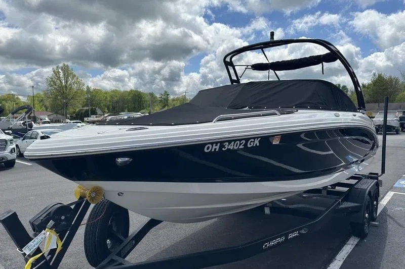 Slide: The Image of 2023 Chaparral 23 Surf boat on trailer under cloudy sky. - 31