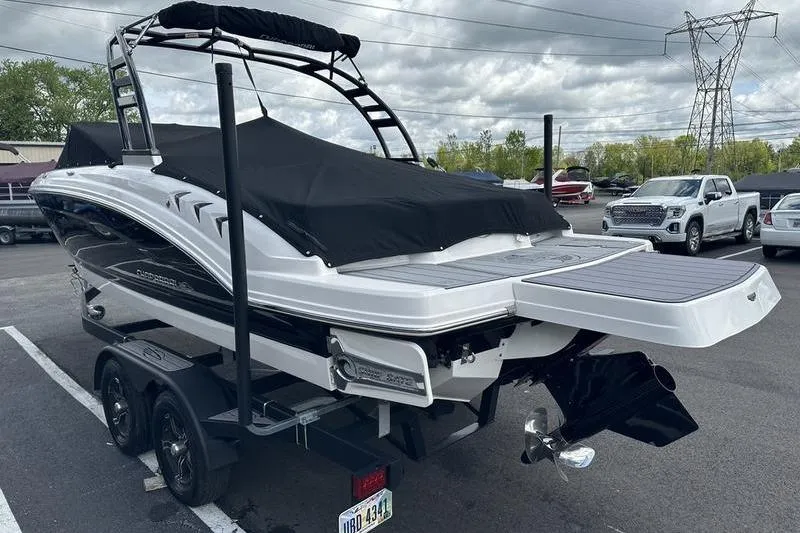 Slide: The Image of 2023 Chaparral 23 Surf boat on trailer, covered, in parking lot. - 32