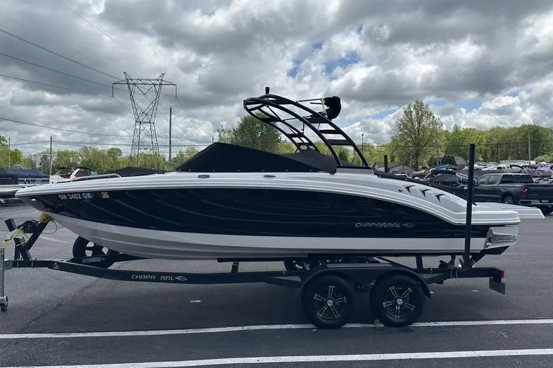 Slide: The Image of 2023 Chaparral 23 Surf boat on trailer under cloudy sky in parking lot. - 33
