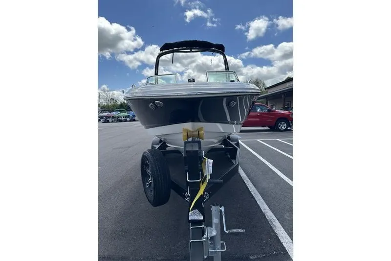 Slide: The Image of 2023 Chaparral 23 Surf boat on trailer in parking lot under cloudy sky. - 6