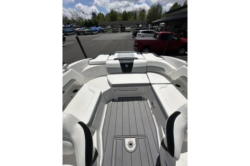 Slide: The Image of 2023 Chaparral 23 Surf boat interior with white seating and gray flooring. - 9