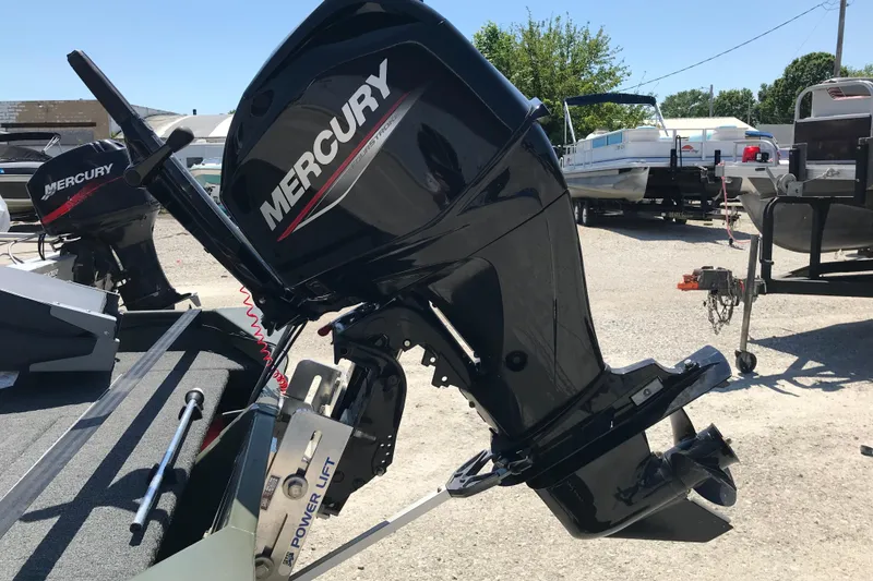 Slide: The Image of 1992 Alweld 1856VV boat with Mercury outboard motor in a sunny marina setting. - 34