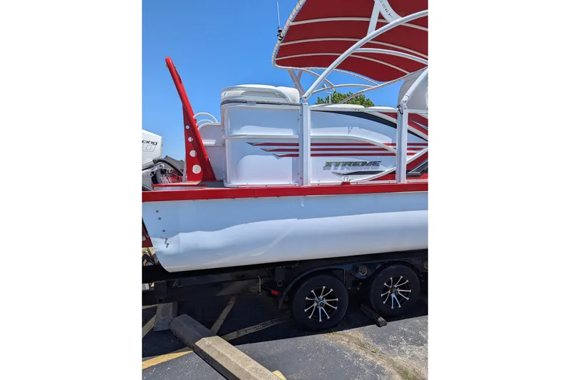 Slide: The Image of 2025 PlayCraft 3000 XTREME boat with red accents on a trailer. - 15