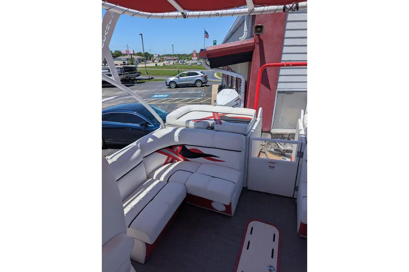 Slide: The Image of 2025 PlayCraft 3000 XTREME boat interior with white and red seating, parked outdoors. - 7