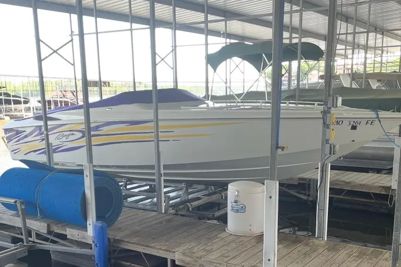 The Image of 2004 Baja 25 Outlaw speedboat docked in a covered marina. - 1