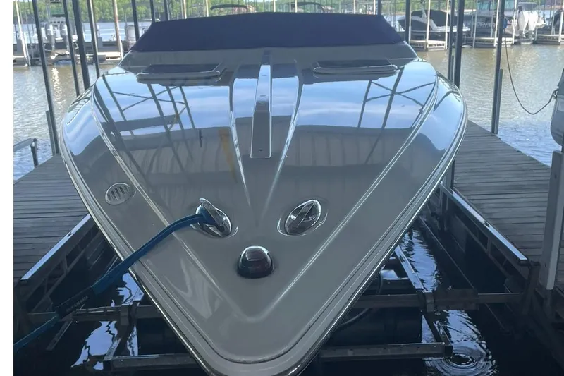 Slide: The Image of 2004 Baja 25 Outlaw speedboat docked in a marina, reflecting water and surroundings. - 4