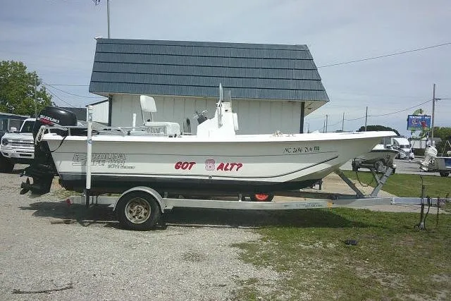 The Image of 2009 Carolina Skiff 198 DLV Elite boat on trailer, parked near a building. - 0