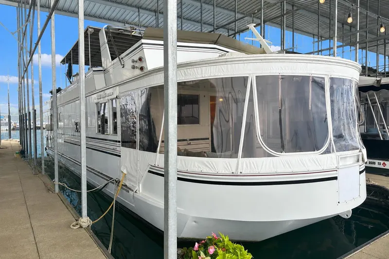 The Image of Houseboat docked in marina, Lazy Days 16x65 model, 1993, with covered deck and clear windows. - 0