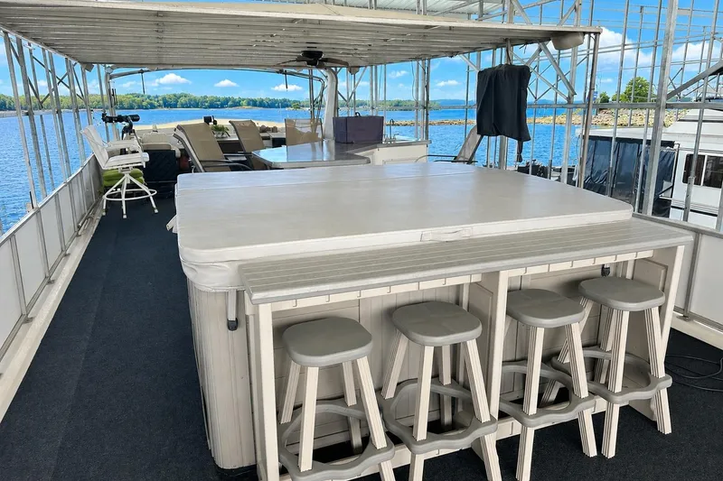 Slide: The Image of Houseboat deck with bar stools, lounge chairs, and scenic lake view. Lazy Days 16x65, 1993 model. - 13