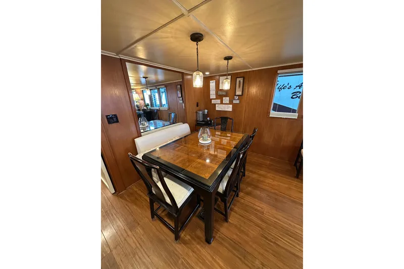 Slide: The Image of Dining area in 1993 Lazy Days 16x65 houseboat with wooden table and chairs. - 5