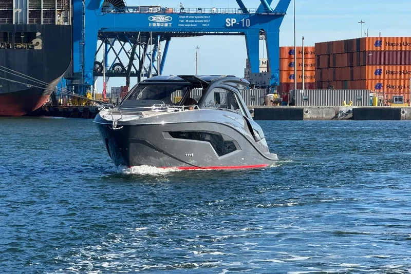 Slide: The Image of 2025 NX Boats NX44 PININFARINA yacht cruising near shipping containers and cranes. - 14