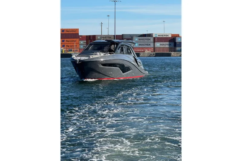 Slide: The Image of 2025 NX Boats NX44 PININFARINA yacht cruising near shipping containers. - 15