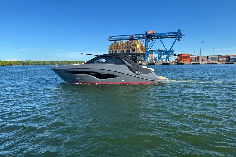 Slide: The Image of 2025 NX Boats NX44 PININFARINA yacht cruising near a busy port with cranes and containers. - 17