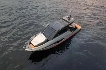 Slide: The Image of 2025 NX Boats NX44 PININFARINA luxury yacht on calm water, showcasing sleek design. - 2