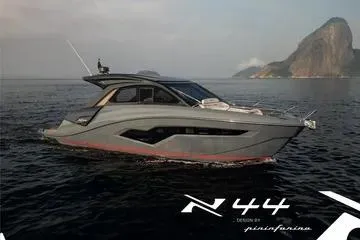 Slide: The Image of 2025 NX Boats NX44 PININFARINA yacht cruising on serene waters with scenic coastal backdrop. - 5