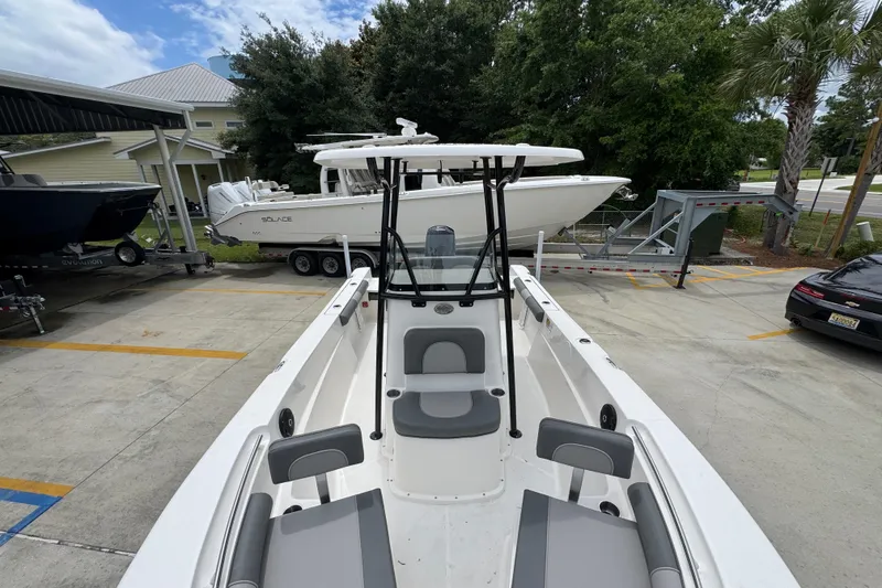 Slide: The Image of 2026 Sea Born LX21 Center Console boat in a parking area, surrounded by trees and vehicles. - 18