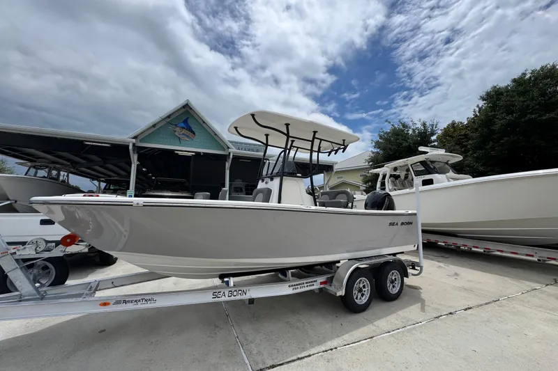 Slide: The Image of 2026 Sea Born LX21 Center Console boat on trailer, parked outdoors under cloudy sky. - 2