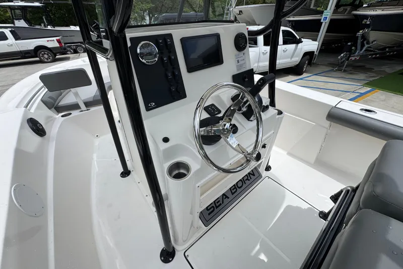 Slide: The Image of 2026 Sea Born LX21 Center Console boat interior with steering wheel and control panel. - 25