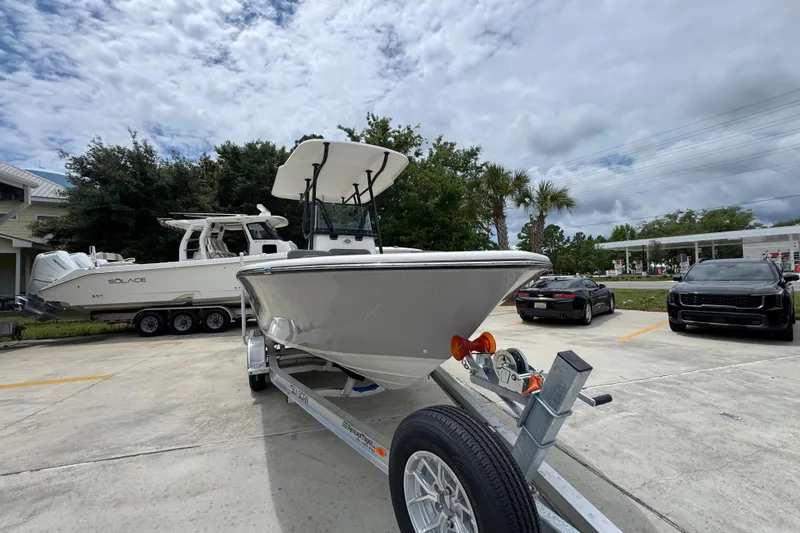 Slide: The Image of 2026 Sea Born LX21 Center Console boat on trailer in parking lot, cloudy sky background. - 6