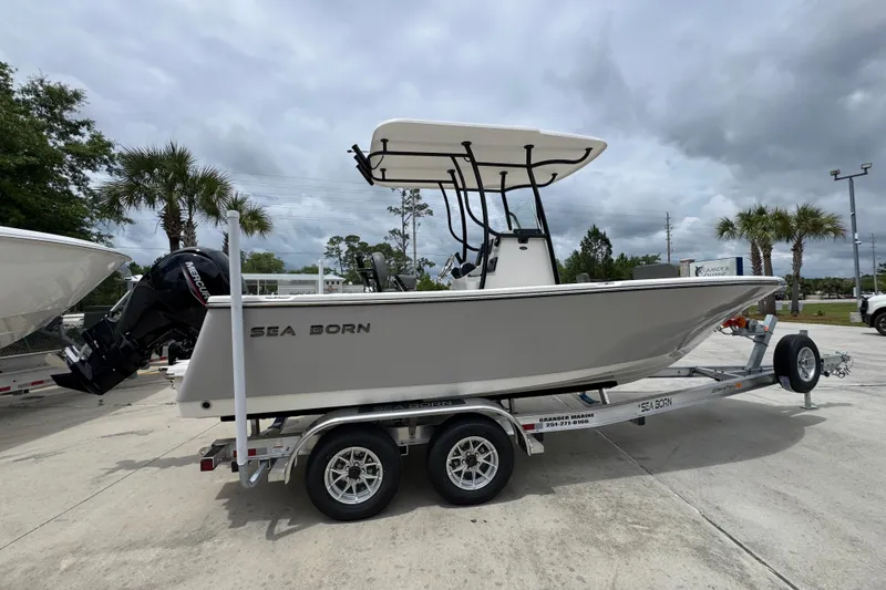 Slide: The Image of 2026 Sea Born LX21 Center Console boat on trailer, parked outdoors under cloudy sky. - 9