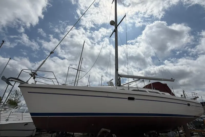 Slide: The Image of 2001 Catalina 380 sailboat under a cloudy sky, showcasing its sleek design and tall mast. - 1