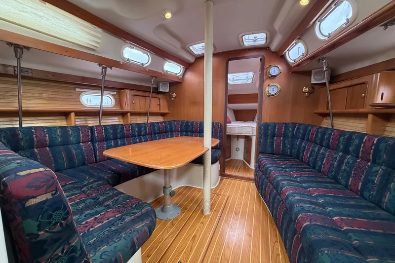 Slide: The Image of Interior of a 2001 Catalina 380 sailboat with cozy seating and wooden accents. - 10