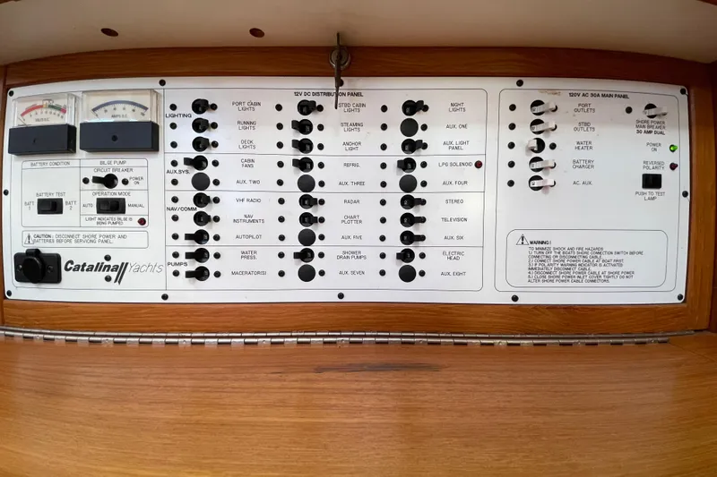 Slide: The Image of Control panel of a 2001 Catalina 380 yacht, featuring various switches and gauges. - 11